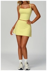 Detail of light yellow yoga set with thin straps and matching sports tennis skirt