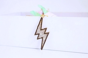 Close-up of lightning bolt keychain with black and clear rhinestones on gold base
