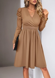 Detail of elegant brown V-neck dress featuring puff sleeves and pleated waist design