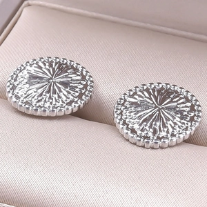 Macro shot of 304 stainless steel round stud earrings featuring sunburst texture details