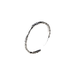 Anello aperto minimalista in argento con texture martellata e motivo irregolare in rilievo