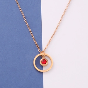Minimalist gold stainless steel necklace featuring a round red birthstone pendant on blue background