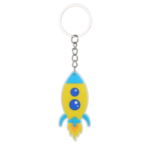 Close-up of yellow and blue rocket keychain with metal ring and chain on white background