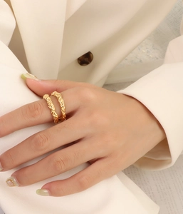 Detailed view of 18k gold double-layered hammer texture rings on model's finger