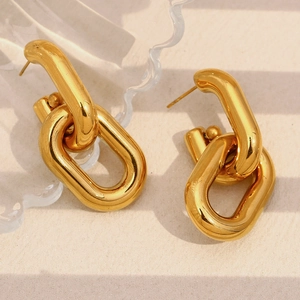 Detailed view of chunky 18K gold plated hollow chain link earrings on a beige surface