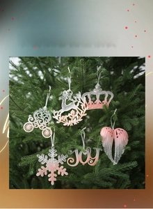 Close-up of pink and white gradient Christmas ornaments hanging on a pine tree branch