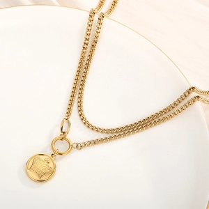 Detailed close-up of double-layered 18k gold plated necklace with crown round pendant