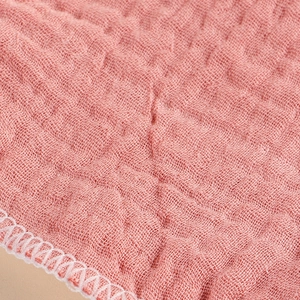 Waschbare rosa Stillpads aus Baumwollmull mit Crinkle-Struktur und weißem Stickrand