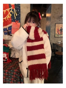 Detail shot of a red and white striped knit scarf with fringes in a festive cafe setting