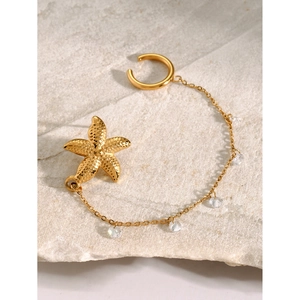 18k gold plated starfish ear cuff with sparkling rhinestone chain on stone background