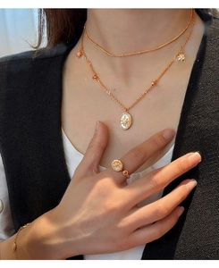 Détails du collier superposé en or rose avec pendentifs étoiles et nacre sur le modèle