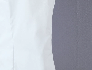Close-up of white plain fabric texture and side stitching detail on a retro shirt