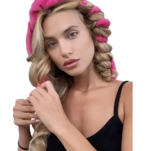 Pink heatless hair curler usage detail showing velvet rollers wrapped in hair for waves