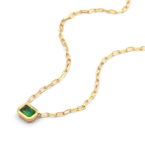 Detail of emerald-cut green gemstone pendant on golden rectangle link paperclip chain