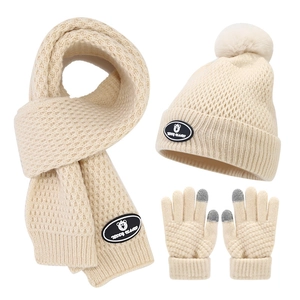 Detail of children's knit set with teddy bear patch, scarf, hat, and touchscreen gloves