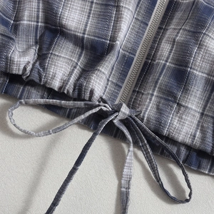 Detail van de blauwe geruite hoodie met verstelbaar trekkoord en metalen rits close-up