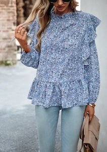 Dettaglio della camicetta blu a fiori con eleganti balze e design a vita stretta