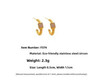Macro shot of twisted gold stainless steel earrings with zircon inlay, size 1.1x0.5cm