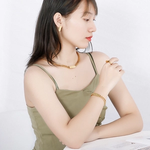 Golden stainless steel Cuban chain jewelry set with square pendant worn by model