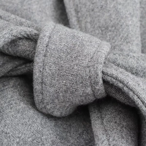 Detailed macro view of the premium grey wool fabric texture and waist belt stitching