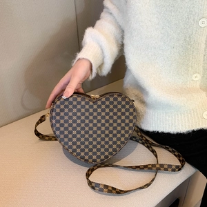 Dettaglio borsa a tracolla marrone a forma di cuore con motivo floreale vintage e zip in metallo