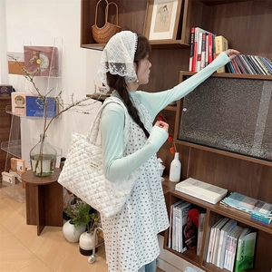 Quilted floral tote bag with cute bear patterns shown in a lifestyle library setting