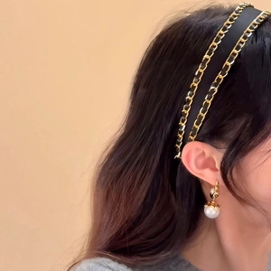 Elegant fabric headband with gold chain and matching pearl drop earrings on a model