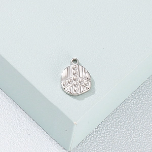 Irregular stainless steel paw print pendant with clear crystal inlay on a blue prop