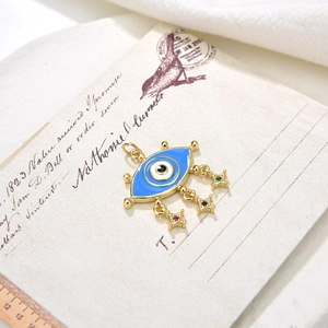 Vintage evil eye pendant with blue enamel and colorful star charms on a retro backdrop