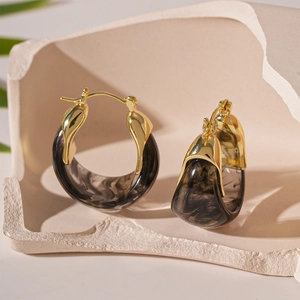 Detail von Vintage U-förmigen Harzohrringen mit Goldmetall und Marmortextur