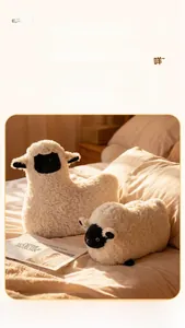 Détail de deux peluches mouton blanches avec texture de fourrure bouclée sur un lit doux