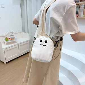 Détail du sac bandoulière en toile blanche avec imprimé fantôme sur un mannequin