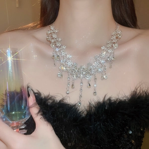 Gros plan d'un collier pampille fleur en argent serti de cristaux porté par un modèle