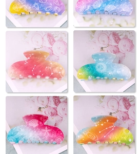 Close-up of gradient shell and starfish hair claws featuring celestial patterns