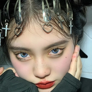 Close-up of punk style silver metal hair clip with cross and heart charms on model