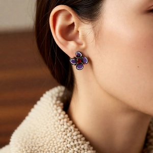 Gros plan sur clou d'oreille fleur vintage avec zircons violets et rouges
