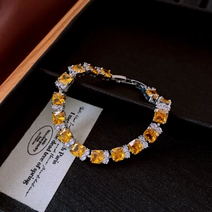 Detail of silver tennis bracelet with yellow square zircons in a premium jewelry box