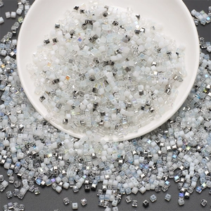Mixed white, crystal and silver square glass beads set in a white ceramic bowl