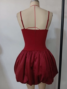 Detail eines dunkelroten Satinkleides mit rückenfreiem Schnitt und weitem Ballonrock