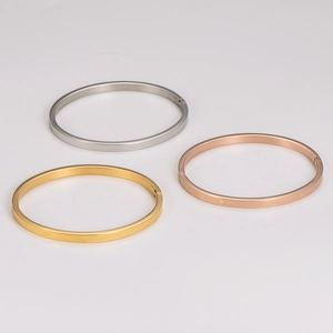 Three-piece stainless steel bangle set in gold, silver, and rose gold with Love Kiss engraving