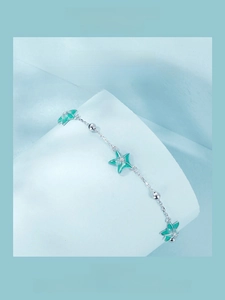 Detail of 925 sterling silver starfish bracelet with teal enamel and sparkling texture