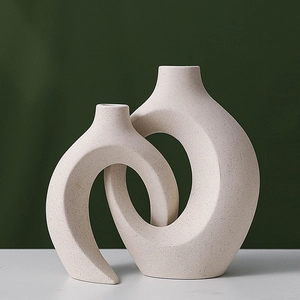Minimalist white ceramic interlocking ring vases with artistic Nordic speckled texture