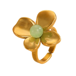 Close-up of golden flower ring featuring a green bead and adjustable petal design