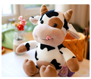 Primer plano de un lindo peluche de vaca manchada en blanco y negro con lengua rosa
