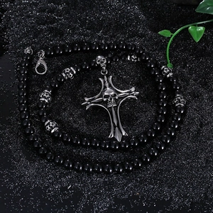 Gothic beaded necklace with silver skull cross pendant on a dark glitter background