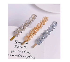 Detail of handcrafted beaded hair clips with crystal flowers in silver and blue tones