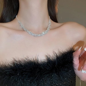 Close-up of sparkling silver twisted necklace set with rhinstones on model neck