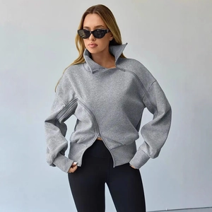 Detail view of the asymmetric zipper design on the grey high-neck sweatshirt
