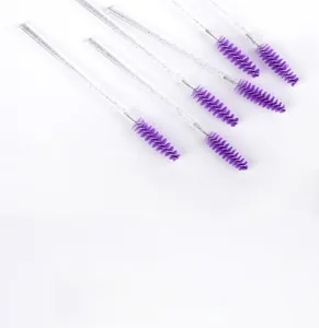 Macro shot of 6 disposable eyelash spoolies with purple heads and silver glitter crystal wands