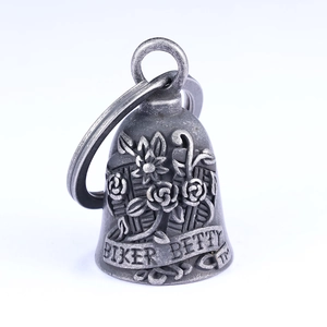 Macro detail of vintage biker bell pendant with rose embossing and Biker Betty engraving